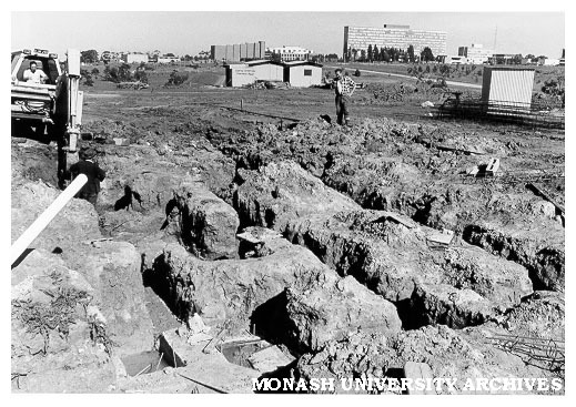 Foundations for Roberts [?] Hall with university buildings in background