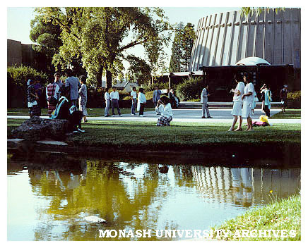 Students in forum near pond, Religious Centre in background
