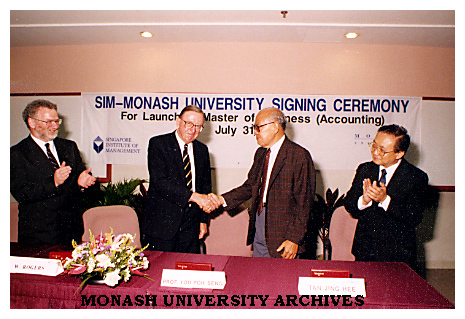 Chancellor Mr Bill Rogers shaking hands with Professor You Poh Seng, executive director Singapoe Institute of Management (SIM). Pro Vice-Chancellor Professor Leo West (left) and SIM executive director Mr Tan Ging Hee applaud
