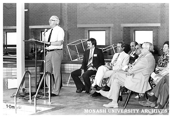 Doug Ellis, Sports &amp; Recreation Association director, speaking at the opening of the swimming pool. Professor Ray Martin (seated middle front row)