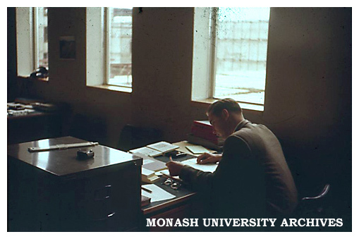 Dr Trevor Hicks at work with Senior Physics building and S5 lecture theatre under construction through window.
