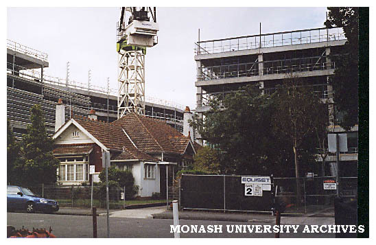 Construction of H building on Caulfield campus with house in foreground.