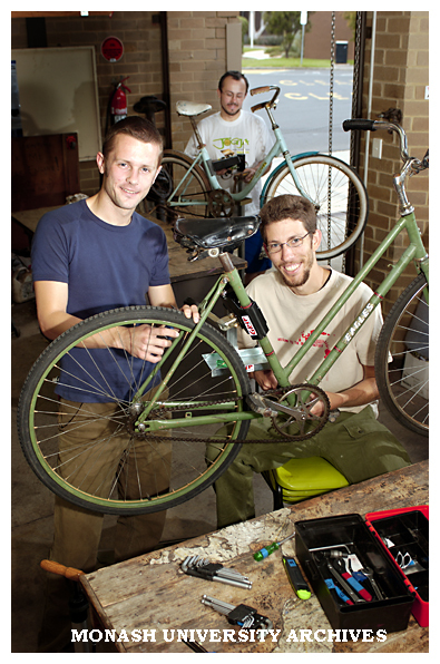Monash students restoring bikes for sale to students. Mr Tom McKendrick (left) and Mr Ian Adams with Mr Rob Prain in the background.