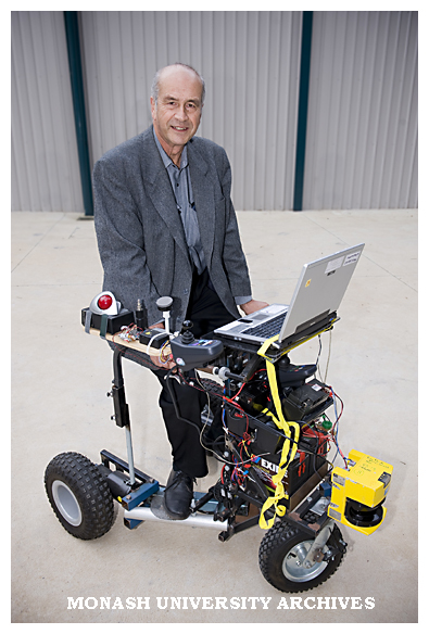 Professor Ray Jarvis, from Electrical and Computer Systems Engineering, with prototype motorised walk-chair.