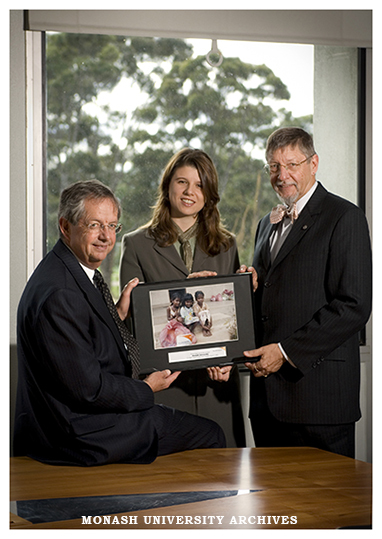 Michelle Gale from World Vision presenting a plaque to Vice Chancellor Professor Richard Larkins and Professor Gary Bouma thanking the university for fund raising for tsunami victims.