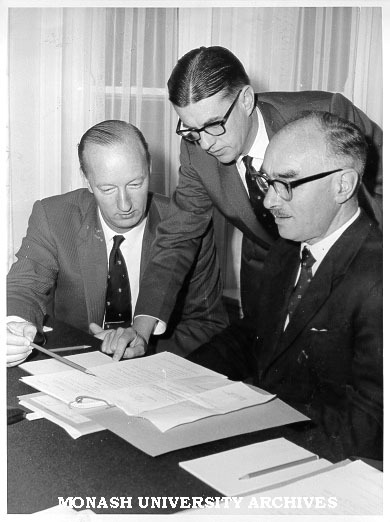 Senior administrators Mr F. H. Johnson (Comptroller)(left), Mr J. D. Butchart (Academic Registrar) and Dr Louis Matheson (Vice-Chancellor) examining agenda for first Professorial Board meeting