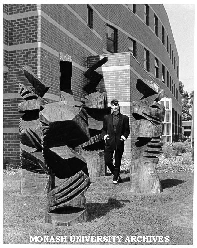 Artist Lyn Moore with iron bark sculptures outside University Gallery