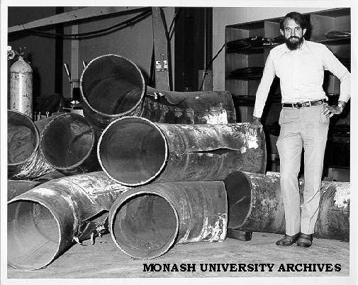 Professor Noel Murray showing rips in mitre bends of tested pipes