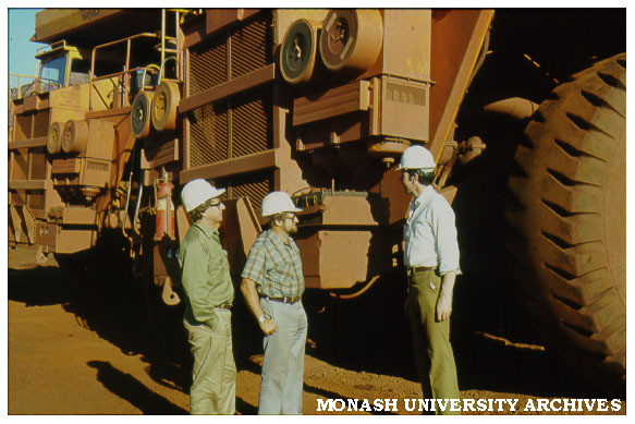 Michael Cass (left), Tim Ealey, and Graham Andrews in front of ore dump truck in Pilbara