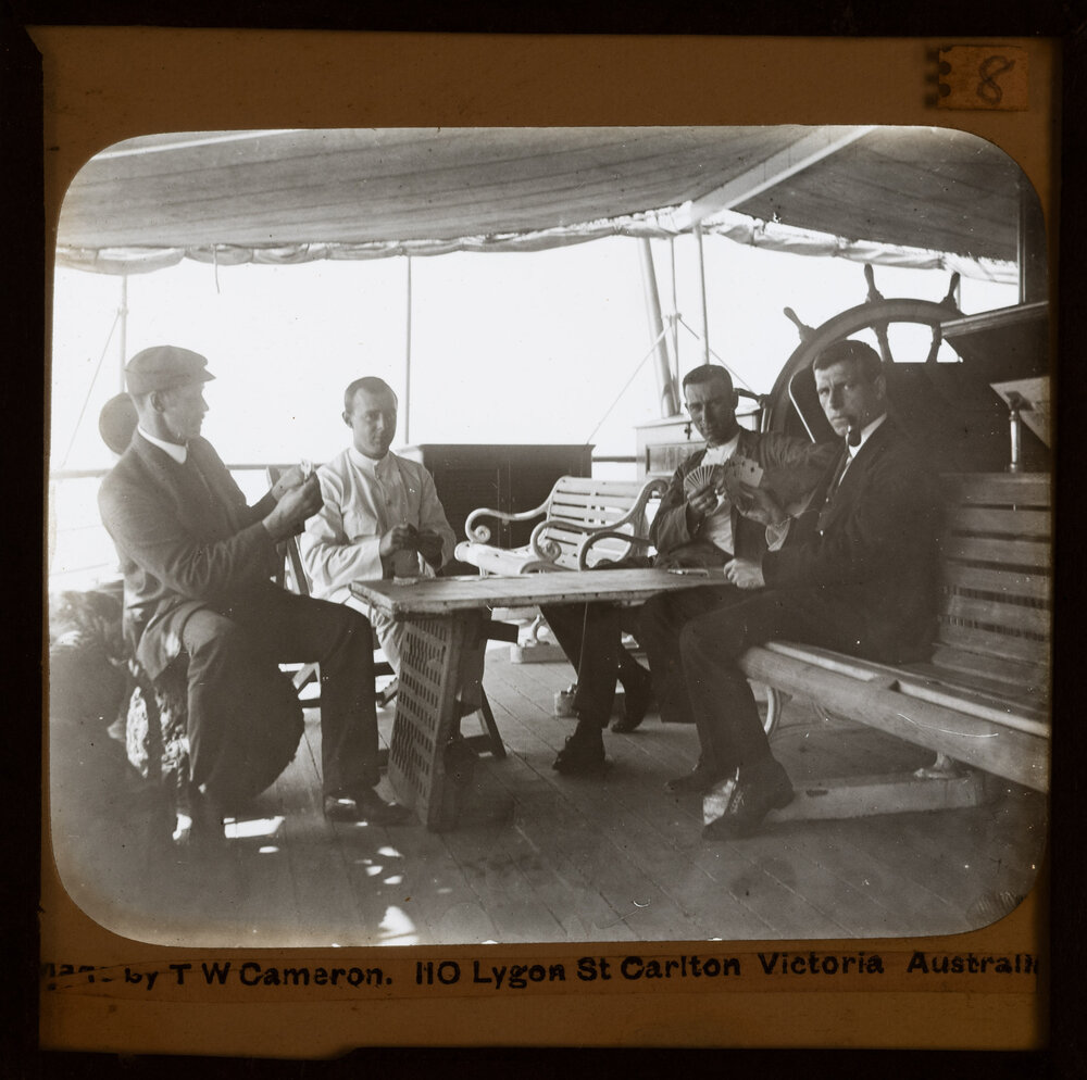 Men playing cards on boat deck 