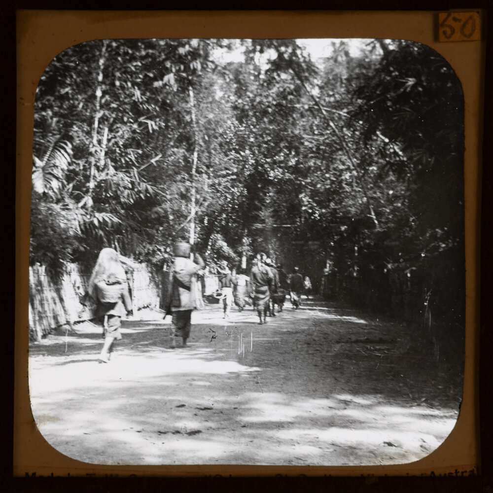  People walking along road carrying baskets 