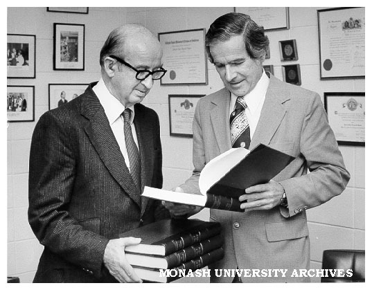 Professor Sir Edward Hughes (left) presenting Vice-Chancellor Professor Ray Martin with bound publications