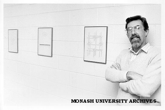 Dr John Stillwell with art work displayed in Mathematics building