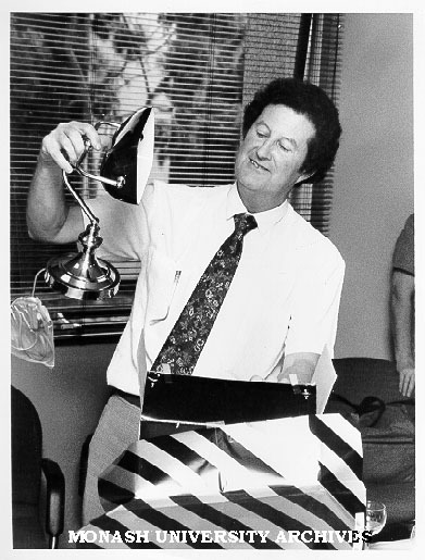 Senior Assistant Registrar for the faculty of Science, Mr George Joyce, unpacking a gift at his farewell before taking up an appointment with Gippsland Institute of Advanced Education