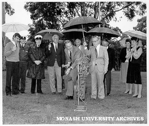 Vice-Chancellor planting Jubilee tree. Professor Ray Martin, onlookers include John Trembath (left), Doug Ellis (fourth left), Keith Bennetts (centre rear), Jim Leicester (fourth right) and Chancellor Sir George Lush (third right).