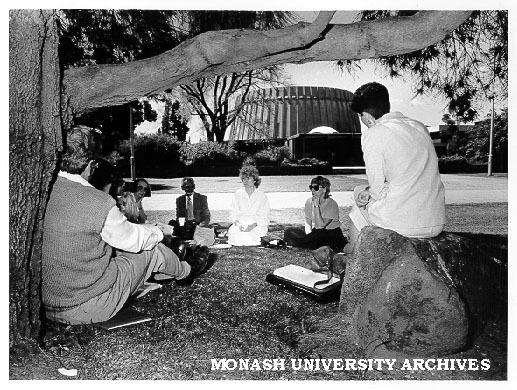 Participants in the multi-faith seminar meeting in university grounds with Religious Centre in background