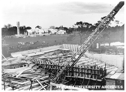 Science lecture theatres under construction, Talbot Colony buildings in background with standing water tower.