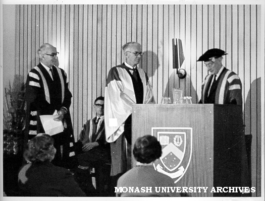 Sir Lindor Brown (centre) receiving honorary Doctor of Science from Chancellor Sir Douglas Menzies, watched by Vice-Chancellor Dr Louis Matheson (left), and Academic Registrar Mr J. D. Butchart (seated)