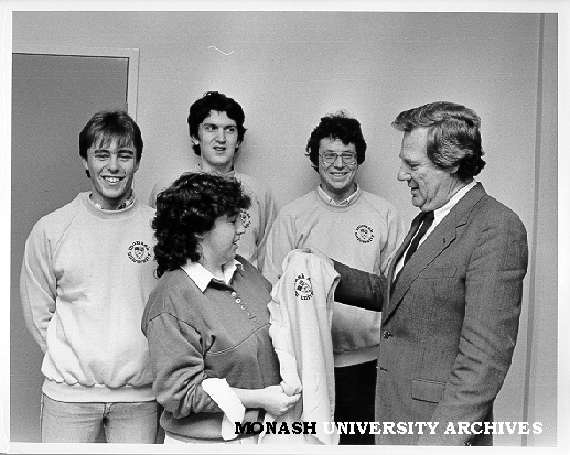 Vice-Chancellor Professor Mal Logan presenting University Challenge team with Monash windcheaters, Trish Byron (front) watched by Brett Maxfield, Nick Laffey and Warren Batchelor