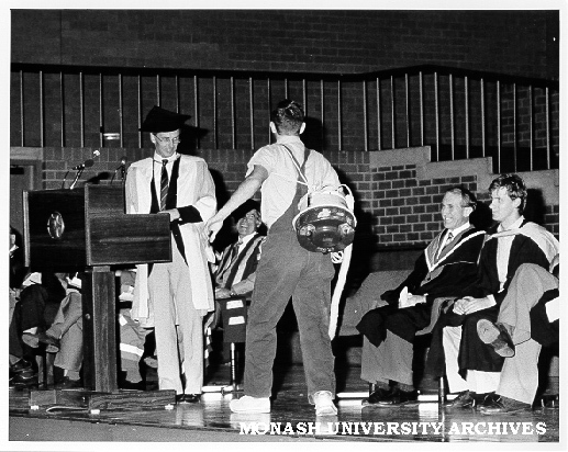 Student carrying out exorcism at opening of Orientation with Professor Alan Henry (standing), Graeme Sweeney and chairman of MAS Steve Hurd