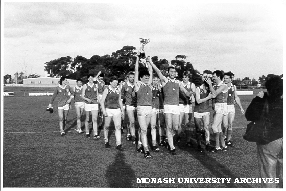 Monash Blues football team with cup aloft after winning 'C' grade final