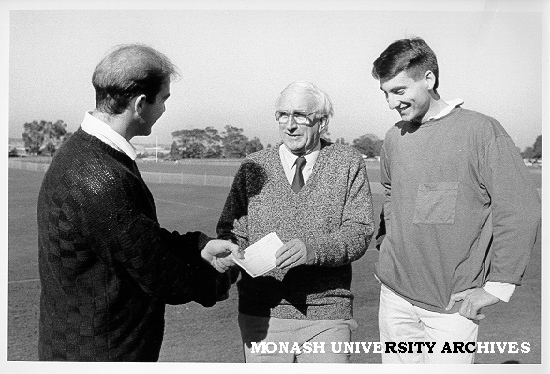 Mr Doug Ellis congratulating rowing team members Justin Negri and Andrew Cohen, on winning Oxford-Cambridge Cup