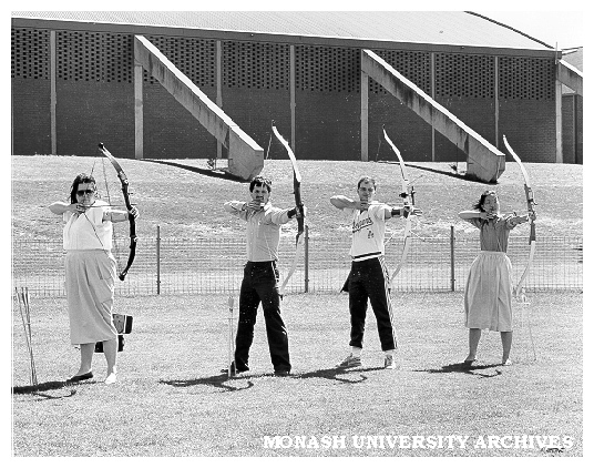Archery Club members Natalie Tampion, Nick Hatzipantelis, David Maccora [and ?], practising on oval behind Sports and Recreation Centre