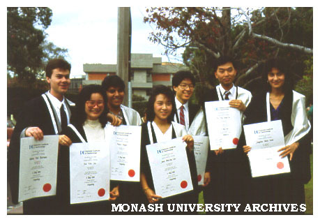 Students displaying testamurs after graduation
