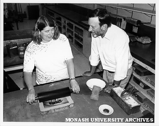 Head of School of Visual Arts Norman Creighton watching lecturer Kaye Green demonstrating art of print lithograph from stone