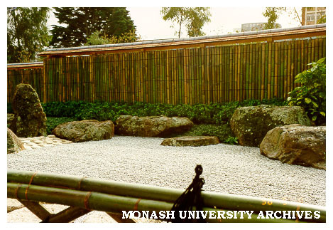 Japanese Garden with Kenninji style bamboo fence with a continuos roof topped in cedar bark with the stone (sekitei) garden in the foreground