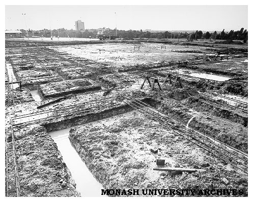 Construction of swimming pool complex with tennis courts in background