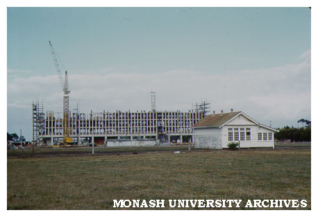 Humanities building, first stage under construction, old school house in foreground