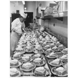 A catering staff member preparing desserts