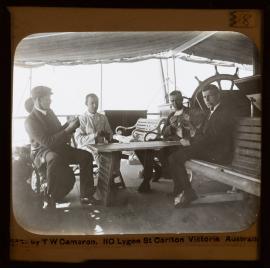 Men playing cards on boat deck 