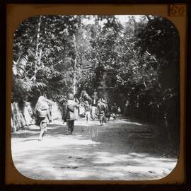 People walking along road carrying baskets 