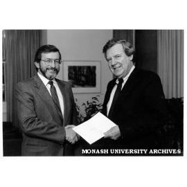 Professor Mal Logan receives a cheque from Mr Peter Cook (Minister for Industrial Relations) to fund the National Key Centre in Industrial Relations