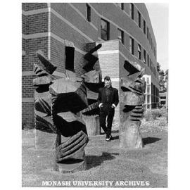 Artist Lyn Moore with iron bark sculptures outside University Gallery