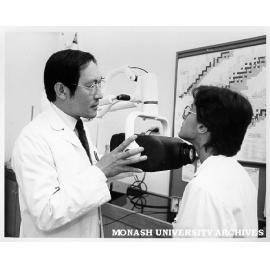 Mr Teng Tan (left) testing student Sylvie Keleman with thyroid monitor