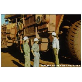 Michael Cass (left), Tim Ealey, and Graham Andrews in front of ore dump truck in Pilbara