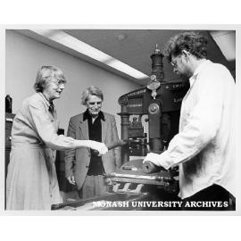 Professor Jean Whyte and Dr Brian McMullin (right) operating Albion press with Emeritus Professor Hector Monro looking on