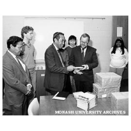 Professor Mahmud Zaki (centre left) Cultural and Educational Attache for Indonesian Embassy in Canberra presenting gift of books to acting chairman of department of Indonesian and Malay, Mr Paul Tickell