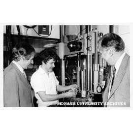 Vice-Chancellor Professor Ray Martin (left) watching student Russell Coade fatigue cracking sample of aluminium casting alloy. Professor Ian Polmear looking on