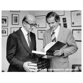 Professor Sir Edward Hughes (left) presenting Vice-Chancellor Professor Ray Martin with bound publications