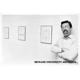 Dr John Stillwell with art work displayed in Mathematics building