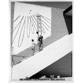 Dr Carl Moppert and Ben Laycock working on sun dial on wall of Union building