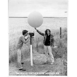 Student Cathy Joyce releasing helium filled balloon to be tracked by double theodolites
