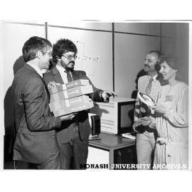 Handover of MONET software to Racal Electronics, Dr Cliff Bellamy (left), Mr Robert Morgan, Mr Roland Horat and Mrs Gail Morgan