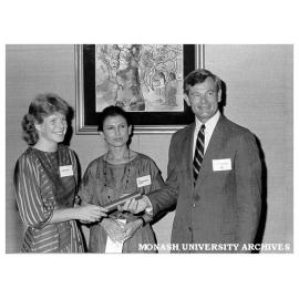 Student Linda Reid (left) being presented with Caltex Woman Graduate Award by Managing Director of Caltex Aust., Mr John McPhail, between them is Dr Alessandra Pucci