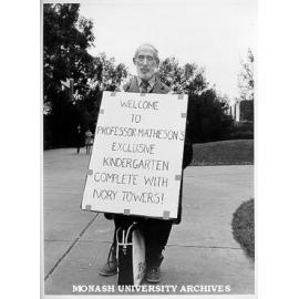 Sandwich board demonstrator. 'Welcome to Professor Mathieson's Exclusive Kindergarten Complete With Ivory Towers!'