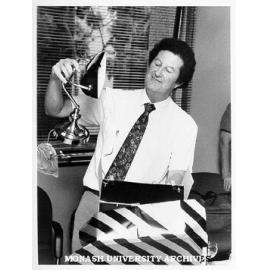 Senior Assistant Registrar for the faculty of Science, Mr George Joyce, unpacking a gift at his farewell before taking up an appointment with Gippsland Institute of Advanced Education